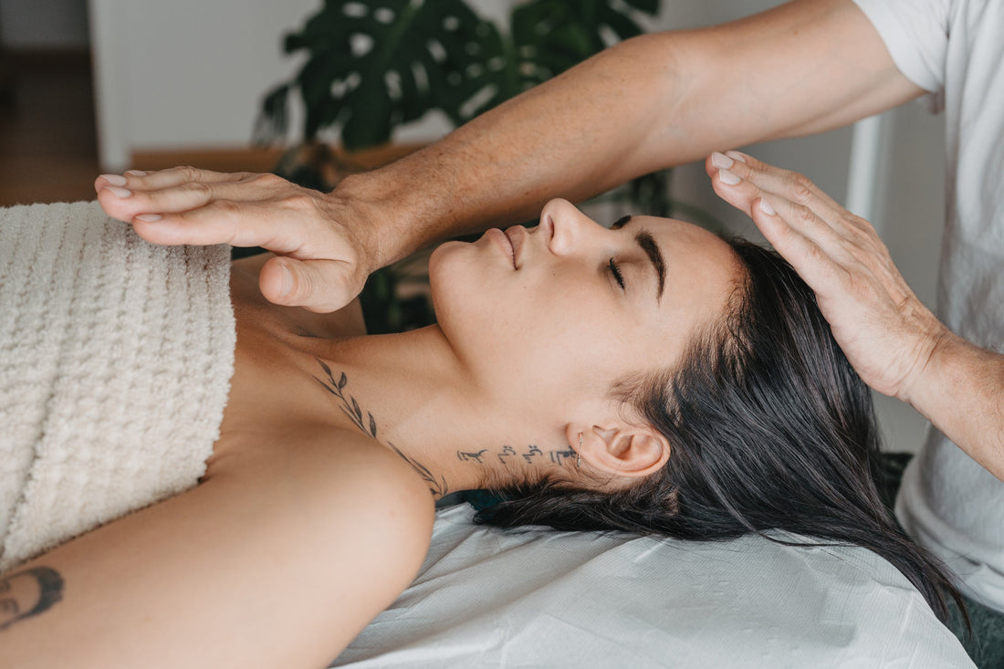 Profile of a woman resting while receiving energy in a Reiki therapy.