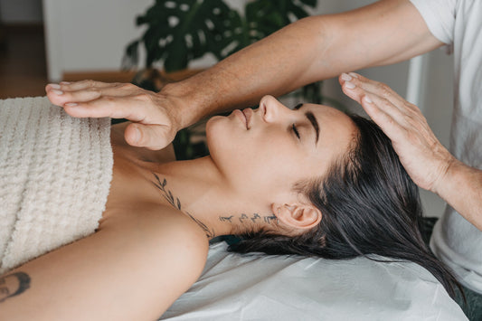 Profile of a woman resting while receiving energy in a Reiki therapy.