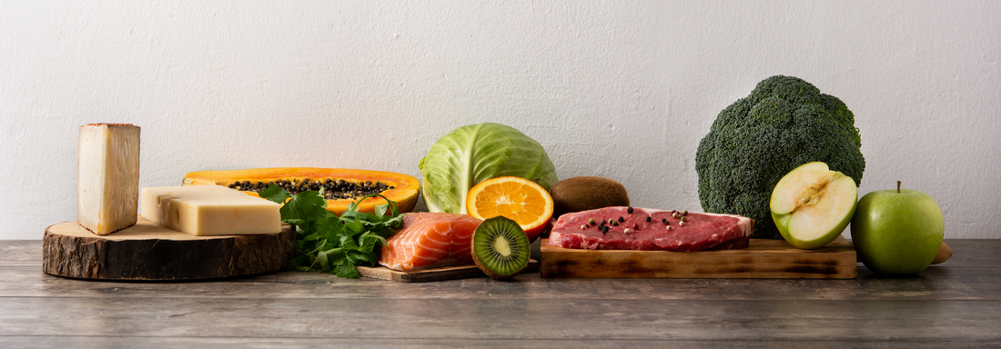 Fruit, vegetables, cheese, fish and meat on wooden table.