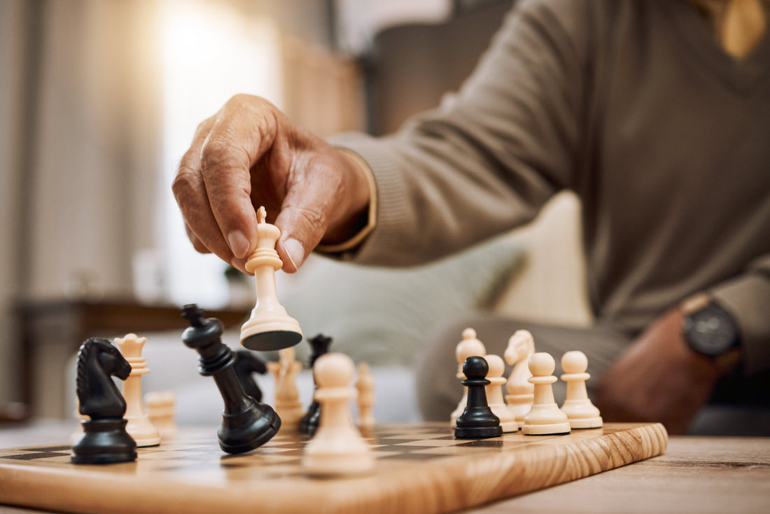 Man, playing hands and chess king in house, home living room in winner strategy, checkmate or board game success.