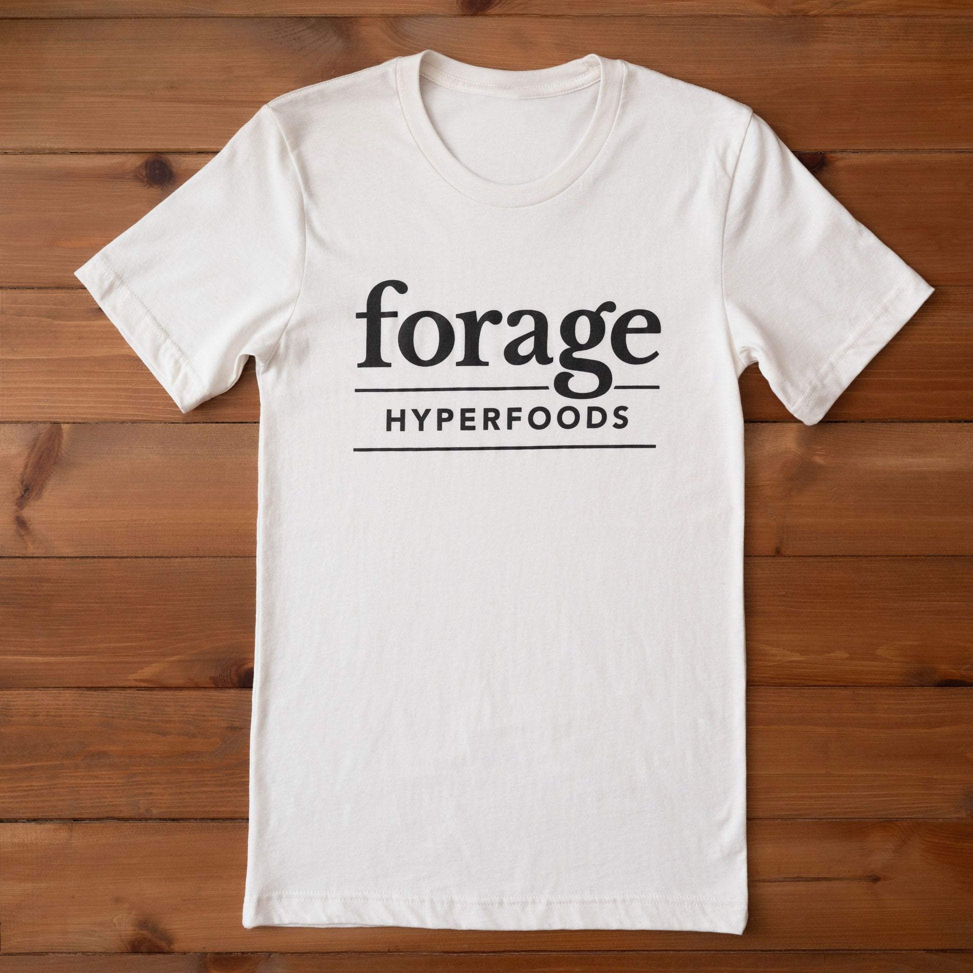 A full lenght vintage white shirt with teh Forage Hyperfoods logo on it. 
