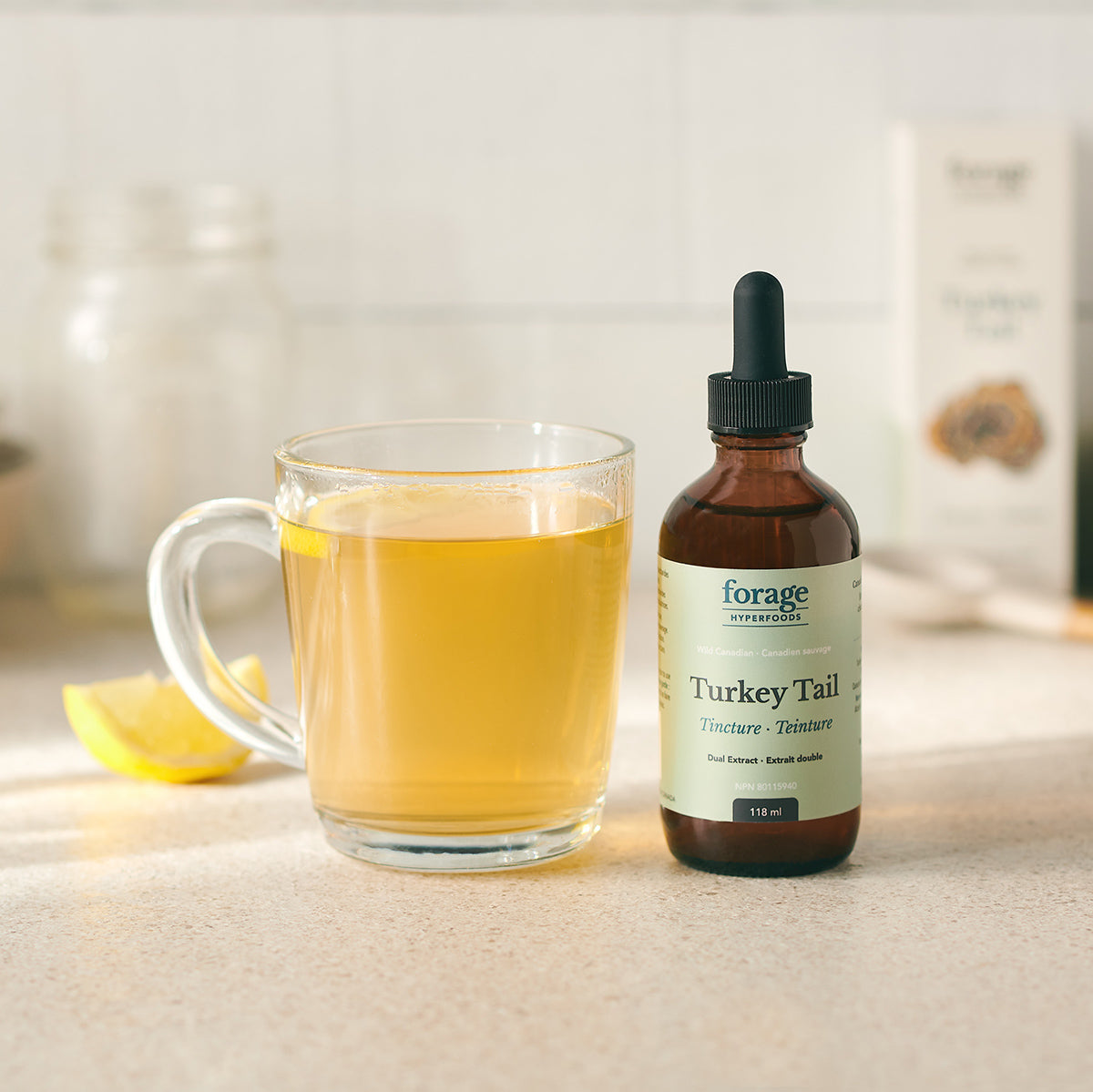 A original turkey tail tincture next to a healthy lemon tea in a glass jar demonstrating the ease of use..