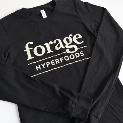 A black shirt with the word mark "Forage Hyperfoods" printed on it in white. It is laid out flat on a white background. 