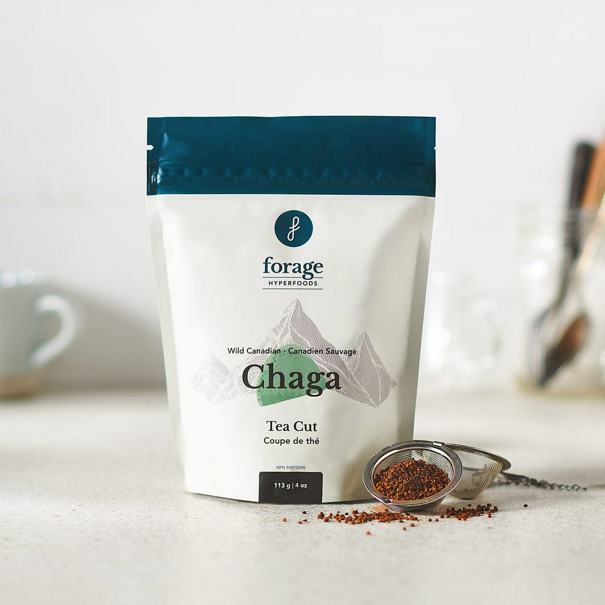 A bag of Canadian Chaga Tea Cut by Forage Hyperfoods with Tea Cut rough coarse powder of Chaga mushroom next to it.